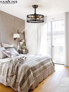 a bedroom with a bed, lamps and curtains on the window sill in front of it