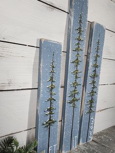 three wooden signs with pine trees painted on them