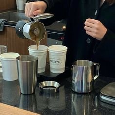 a woman pours coffee into two cups