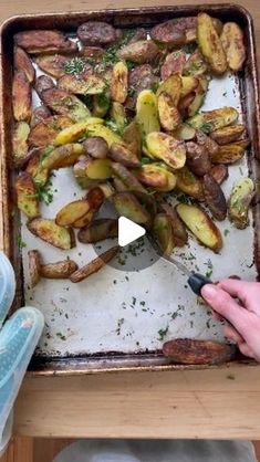 someone is cutting up some potatoes on a sheet with a large spatula in front of them