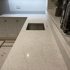 a kitchen counter top with a sink and oven in the backgrounf area