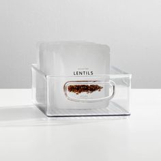 a clear plastic container with some food in it on a white table next to an empty box