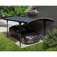 a car is parked in the driveway under a metal carport attached to a house