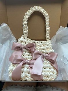 a white purse with pink bows in a box