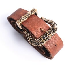 🕯️ FULL GRAIN LEATHER & SOLID BRASS - This medieval style belt exudes quality and craftsmanship. 3 mm, full grain buffalo leather makes for a sturdy, yet supple belt while the buck and tip are cast from solid brass. 🕯️ MEDIEVAL STYLE FIT - Each belt features a 62" long, naturally finished brown leather belt strap with a soft, yet rustic finish. Belt is 1.75" in width and weighs a total of 11 oz. The belt is not worn in the traditional style with a modern belt loop, but instead is worn by l Viking Belt, Bow Bracelet, Dice Bag, Viking History, Brown Leather Belt, Medieval Fashion, Brass Buckle, Buffalo Leather, Animal Companions