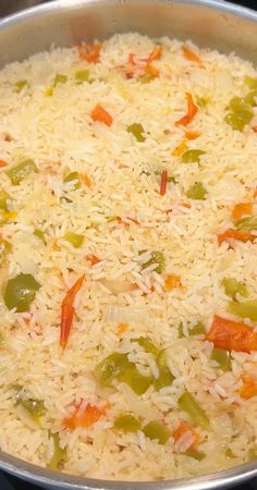 rice and vegetables are mixed together in a pan on the stove top, ready to be cooked