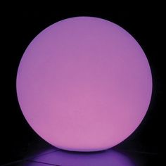 a purple ball sitting on top of a black floor