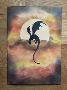 a painting of a dragon flying in front of a full moon on a wooden surface