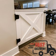 a white barn door with black hardware on the front and side paneling in an open living room