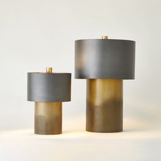 two gray and gold lamps sitting next to each other