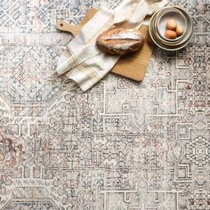 bread and eggs are sitting on top of a rug