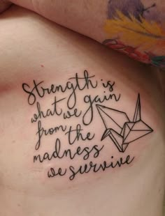 a woman's stomach with a tattoo saying strength is what we gain from the madness