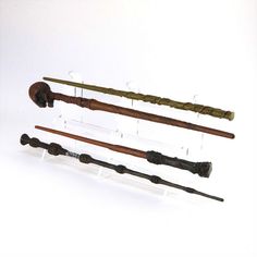 an assortment of old fashioned wooden items on display in a glass holder with acrylic stick holders