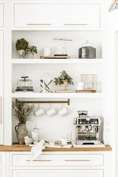 a kitchen with white cabinets and open shelves