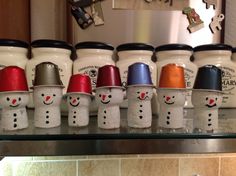 there are many coffee cups lined up on the shelf in front of the counter top