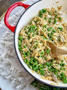 a pan filled with peas and rice on top of a doily next to a wooden spoon