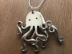 an octopus pendant is shown on a wooden table