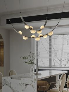 an elegant dining room with marble counter tops and chairs, along with modern lighting fixtures