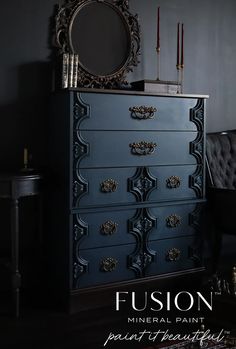 a black dresser with an ornate mirror on top