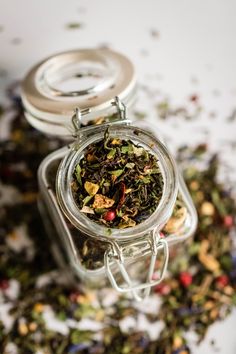 a glass jar filled with lots of different types of tea