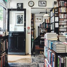 a room filled with lots of books next to a doorway