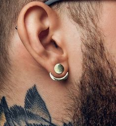 a man with tattoos on his neck and behind the ear is a pair of earrings