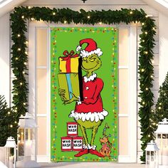 the grinch is holding a christmas present in front of a green background with lights