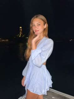 a beautiful young woman standing on top of a boat