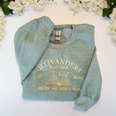 This cozy and durable 10 Oz heavyweight hoodies are perfect for any wizarding fan. Made from a blend of cotton and recycled polyester, they make great gifts or a wonderful treat for yourself. Our hoodies features a unique embroidered design inspired by the wizarding world #OllivandersSweater #Ollivanders #HarryPotter #HarryPotterSweater Elizabeth Core, Embroidered Sweaters, Harry Potter Shirts, Bookish Merch, Academia Fashion, Detailed Embroidery, Embroidery Sweatshirt, Embroidered Crewneck, Christmas Things