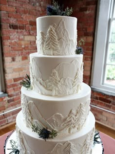 a three tiered white cake sitting on top of a table