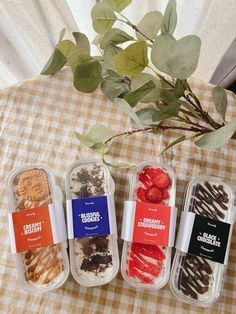 four desserts in plastic containers sitting on a table