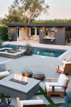 an outdoor patio with fire pit and chairs