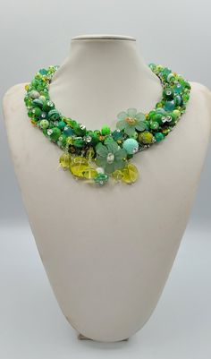 Each piece of our statement necklaces is handmade and one of a kind made in Italy. Our creations is made of high quality materials such as crystals and rhinestones. Each embroidered material is carefully hand sewn. Very glamorous and stylish. Perfect gift to someone you like. Materials Strass stones in Crystal and Green color in different shape and dimension.  Black eco leather backing. Aluminium color hook closure. Measurements Weight approximate 150 grams. Circumference approximate 59 cm - 23,22 in Feel free to contact us if you have any question. Thank you so much for looking at our shop and our articles each of them, single piece. Green Glass Necklace For Party, Green Costume Jewelry Beaded Necklace, Green Costume Jewelry Necklace, Green Crystal Beaded Necklaces As Gift, Green Crystal Beaded Necklace For Gift, Unique Green Glass Necklaces, Unique Green Glass Necklace, Handmade Green Crystal Necklaces, Unique Crystal Beaded Necklace