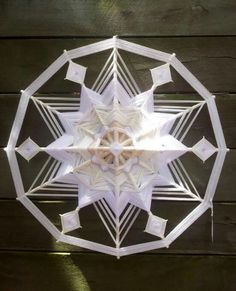 a white paper snowflake sitting on top of a wooden table