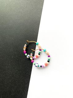 Small and colorful, beaded hoop earrings. Light weight with a bright, summer-y mix of colors. Made with a high quality mix of gorgeous seed beads. ✨Each piece is handmade to order and one-of-a-kind with variations in bead order.✨ Gold plated, 3/4 inch hoops. Looking for larges sizes? Medium Beaded Hoops: https://etsy.me/3xXuyrh Large Beaded Hoops: https://etsy.me/3nUPnzf 🌎 Packaging 🌎 To be environmentally responsible about packaging we will package orders together in the same box. If certain Adjustable Hoop Beaded Earrings With Colorful Beads, Multicolor Beaded Hoop Earrings For Festivals, Multicolor Beaded Hoop Earrings For Beach, Adjustable Multicolor Hoop Earrings For Beach, Multicolor Beaded Hoop Jewelry, Trendy Hoop Beaded Earrings With Colorful Beads, Trendy Multicolor Hoop Earrings For The Beach, Playful Multicolor Hoop Jewelry, Multicolor Beaded Hoop Earrings Gift