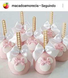 there are pink and white candy apples with bows on them