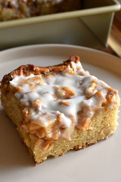 a piece of cake sitting on top of a white plate next to a pan filled with food