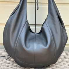 Slouchy Hobo Bag With A Unlined Interior And Attached Zip Pouch. Measures 19.5”Wx14”Hx1”D. Strap Drop 10”. Elegant Black Hobo Shoulder Bag, Luxury Black Hobo Bag For Errands, Luxury Hobo Shoulder Bag For Everyday, Luxury Hobo Bag For Everyday, Luxury Black Textured Leather Hobo Bag, Modern Hobo Bag With Leather Lining For Errands, Luxury Hobo Bag For Travel, Luxury Hobo Travel Bag, Luxury Black Hobo Bag With Leather Lining