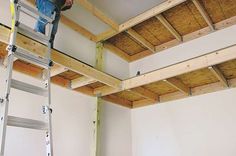 a man standing on a ladder working on the ceiling