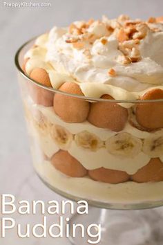 a banana pudding in a glass dish with whipped cream and walnuts on the top