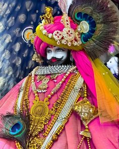 an elaborately decorated costume with feathers and jewels on it's head is displayed