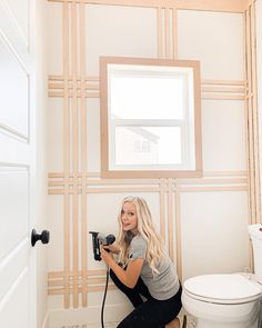 a woman kneeling on the floor with a blow dryer in her hand