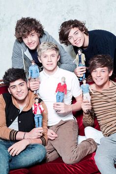 four young men are posing for a photo with their toy figures in front of them