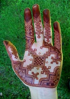 the hand is decorated with red and white designs on it's left palm, which has an intricate pattern in the middle