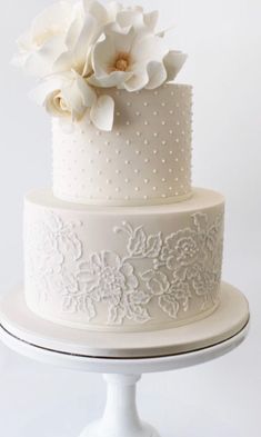 a three tiered cake with white flowers on top