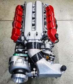 the engine of a car is shown in this aerial view, with red and silver parts