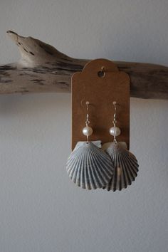 No two shells are alike and that's what makes these earrings so special. These scallop shells were found off the beaches of CT & RI. Paired with pearls, these scallop shells make the perfect set.  Made with silver coated brass & copper wire, plastic pearls & sterling silver earring wires. All shells are found, properly cleaned & up cycled.  Each purchase is packaged in a 100% recycled jewelry box, a 100% recycled padded mailer, 100% recycled tissue paper & hemp twine. Handmade Silver Shell-shaped Pearl Earrings, Mother Of Pearl Shell With Pearl Drop, Handmade Pearl Shell-shaped Earrings, Dangle Shell Earrings With Pearl Drop, Handmade Pearl Earrings In Shell Shape, Dangle Pearl Drop Shell Earrings, Pearl Drop Shell Earrings, Pearl Drop Dangle Shell, Beach Shell Earrings With Pearl Charm