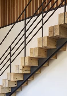 a wooden stair case with metal handrails and wood treading on the bottom