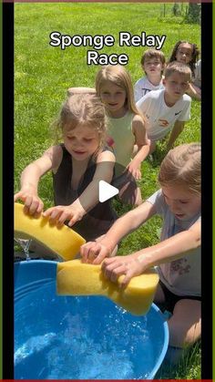 children are playing with sponge relay in the grass