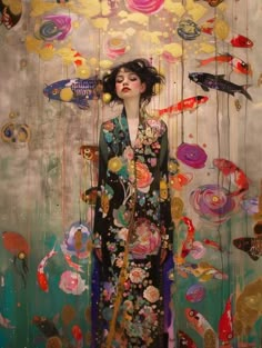 a woman standing in front of a painting with fish and bubbles hanging from the ceiling